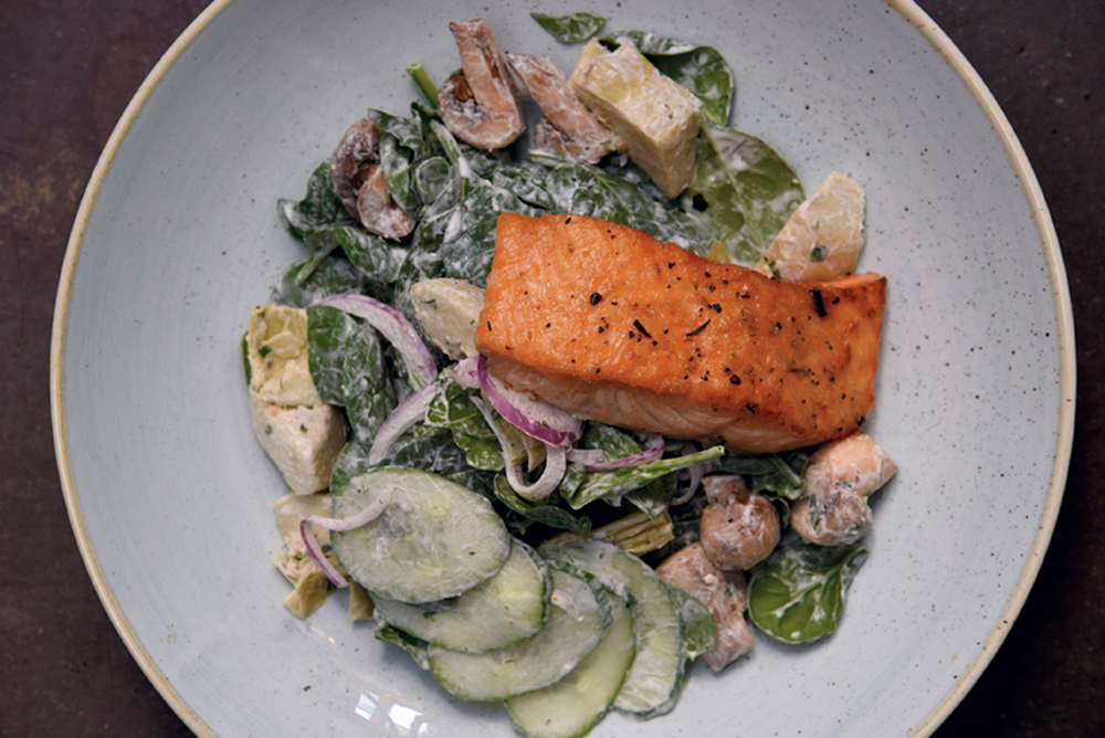 Pan-seared Scottish salmon over a salad of baby spinach and artichoke hearts with a lemon-dill crème fraîche