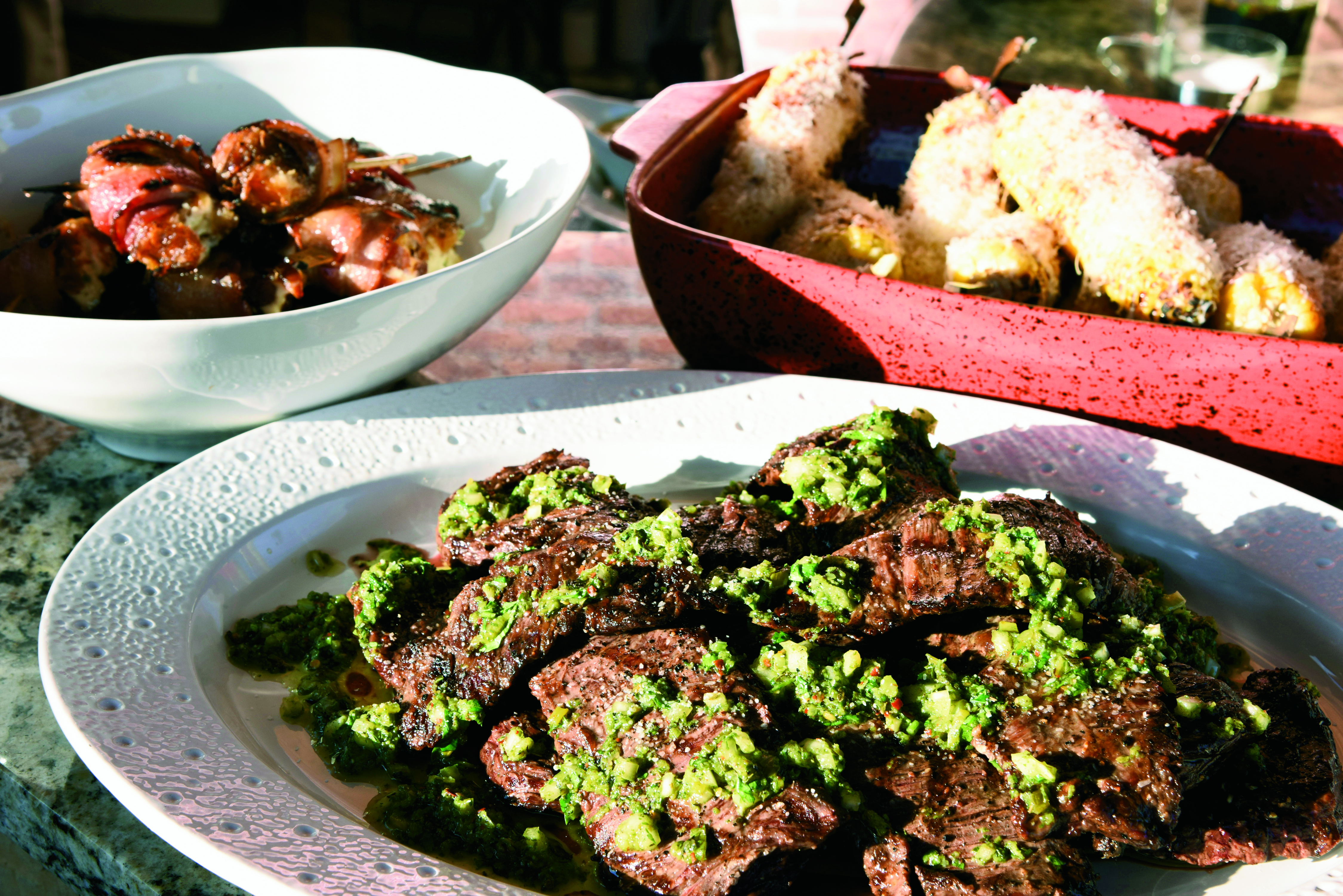 (clockwise from left) Stuffed dates. Mexican-style corn on the cob, Carne asada with chimichurri sauce