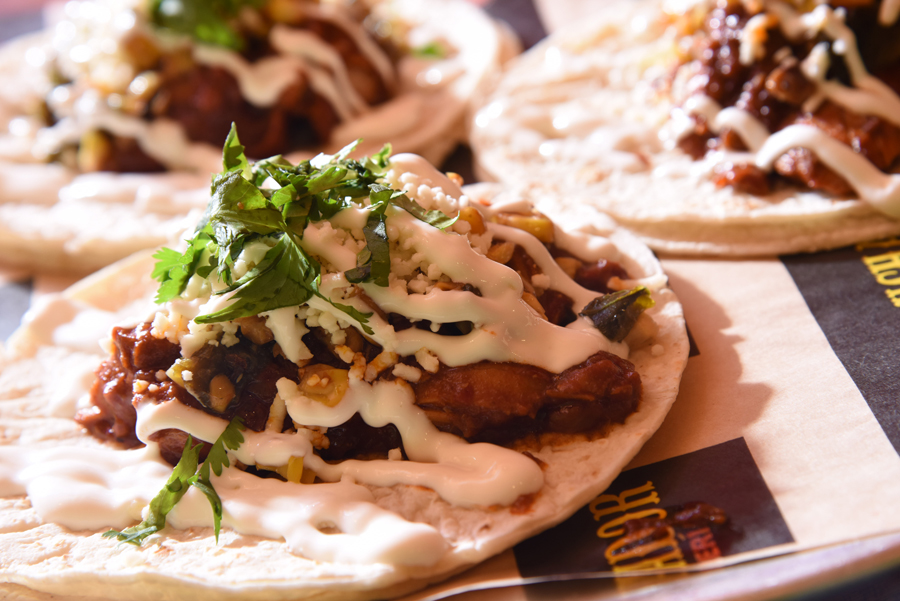 El Taco Luchador’s Mole taco with braised chicken, roasted corn-poblano, crema, and queso fresco